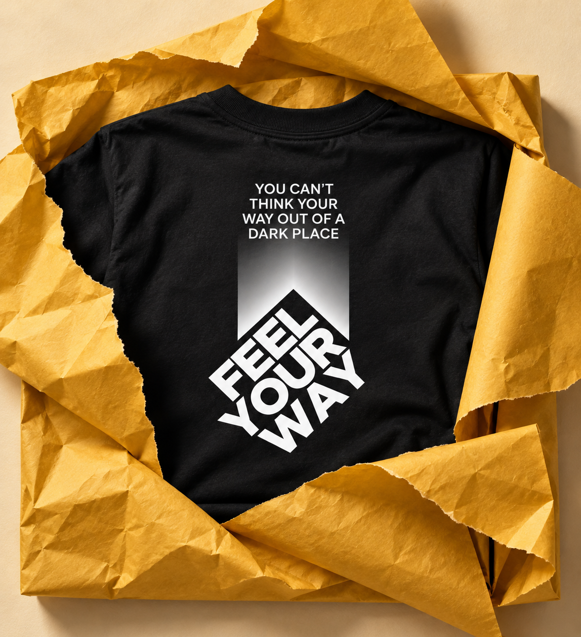 Black You Can’t Think Your Way, You Feel Your Way T-shirt in yellow tissue paper.
