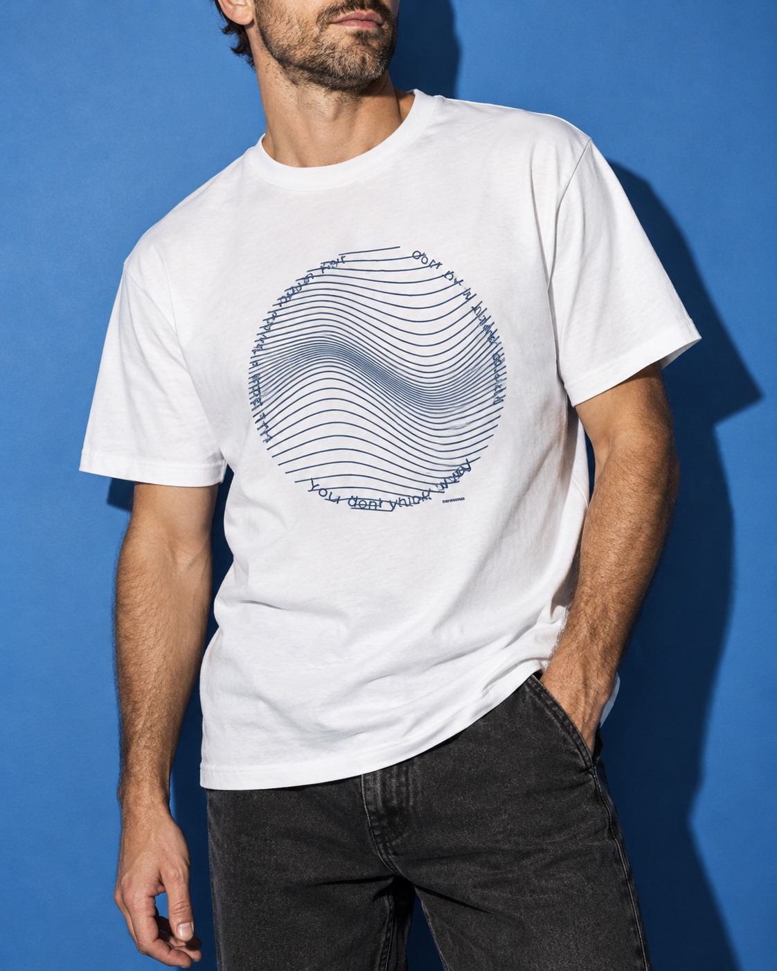 Close view of a white You Don’t Think Your Way T-shirt with circular blue wave artwork.